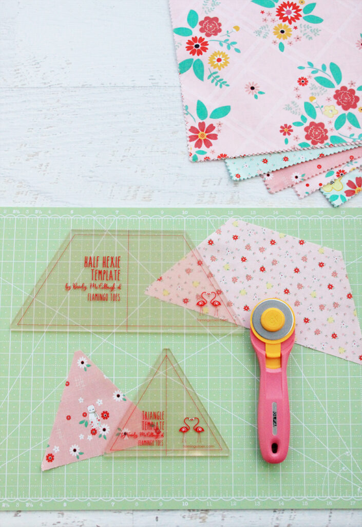 New Quilting Templates on the Way! by popular Tennessee quilting blog, Flamingo Toes: image of the half hexie  and triangle template on a green rotary board next to a rotary cutter. 